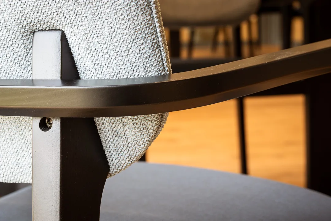 Detail van een stoel met houten armlegger