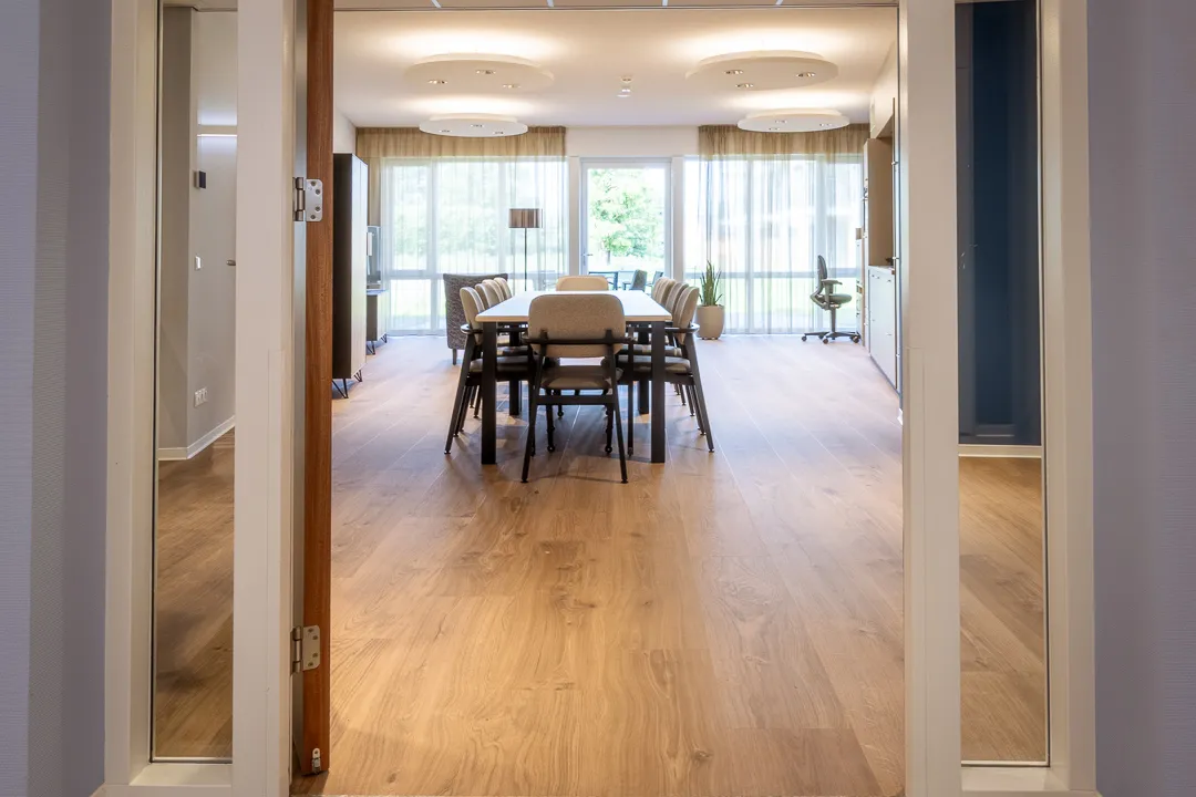 Doorkijk naar een eetruimte met houten vloer
